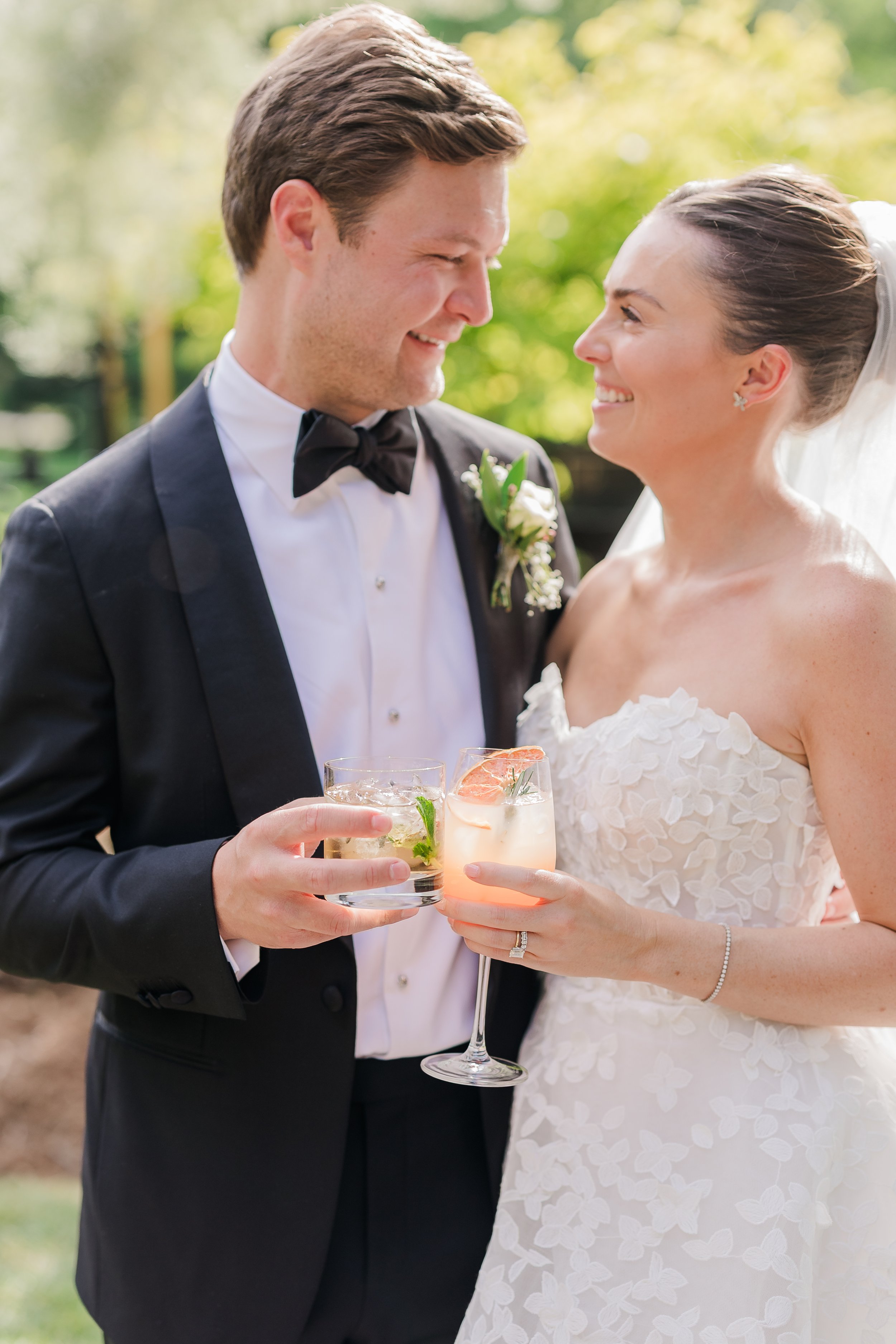 Bride and groom toasting craft cocktails at outdoor reception