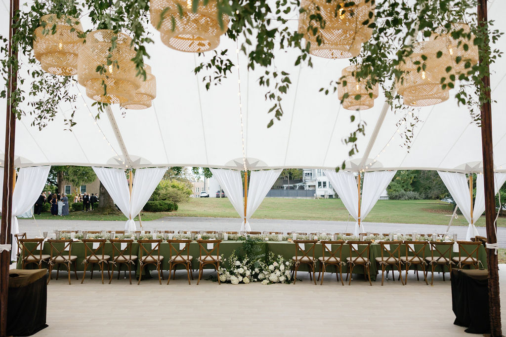 Reception tent interior with pendant lights and greenery